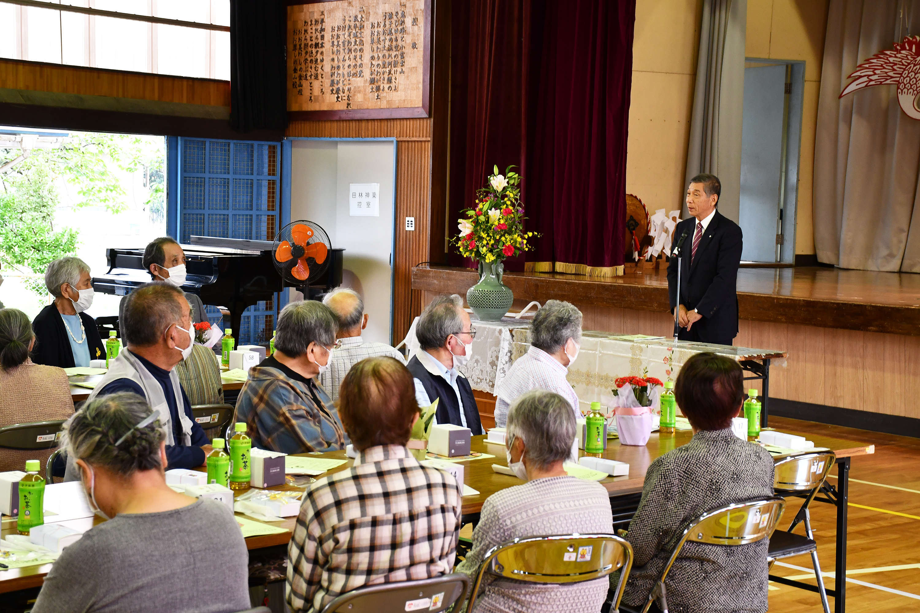金山地区敬老会でお祝いの言葉を話す町長
