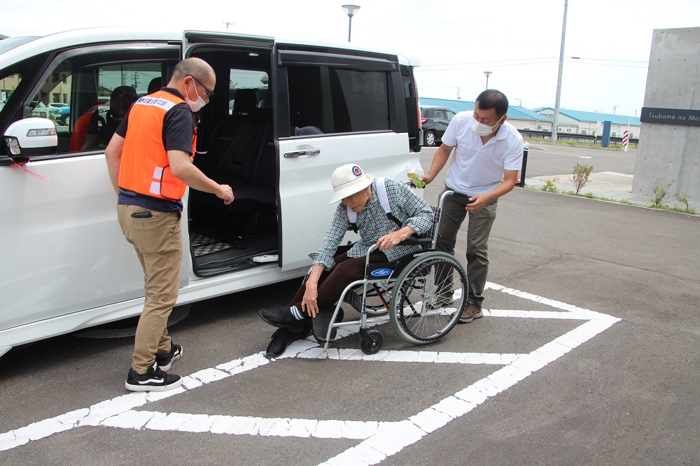 要支援者を車いすに乗せる様子